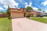 Two-story residence featuring a tile roof, stucco exterior, two-car garage, and a patterned paver driveway