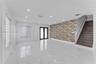 Open-concept room featuring large-format tile flooring, recessed lighting, double-door entryway, patterned accent wall, and staircase with wood-finish