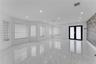 Open-concept area featuring polished porcelain tile flooring, recessed lighting, textured stone accent wall, dual-entry doors with frosted glass panel