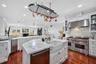 A chef’s kitchen with personality and character featuring distinctive, distressed, finish cabinetry, Premium, Wolf, Appliances, and beautiful marble s
