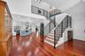 A striking architectural staircase with decorative rod, iron railings and warm wood, treads adds character and sophistication to the grand entry. Rich