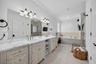 A generously sized primary bath, featuring an expansive, dual sync, vanity, abundant, cabinetry, and counter space, a relaxing, soaking tub and a sepa