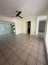 Neutral-tone ceramic tile flooring, three-blade ceiling fan, crown molding, and recessed lighting