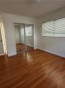 Wood-finish flooring, sliding mirrored closet doors, and window blinds