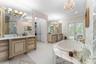 Master bath with dual vanities and door leading to private screened porch
