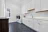 Thoughtfully Designed Laundry Room with Ample Cabinetry and Utility Sink