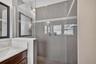 A separate, oversized walk-in shower features elegant tilework, offering a luxurious spa-like experience.