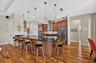 Stylish pendant lights illuminate and accent the spacious kitchen peninsula.