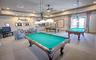 Enjoy a classic game-room experience in the dedicated billiards room, featuring pool tables and comfortable lounge seating.