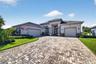 An expansive paver driveway offers ample parking and sets a warm, elegant tone the moment you arrive.