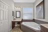 Pamper yourself in an elegant primary bath complete with a built-in makeup vanity and ample closet storage.