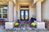 An inviting front porch sets a sophisticated tone upon arrival, complete with beveled glass double doors that seamlessly blend privacy with natural li