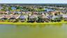 An aerial drone perspective captures the rear elevation of the home, perfectly positioned along the lake.