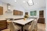 An oversized quartz kitchen island that handles both meal prep and homework.