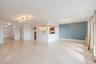 Unfurnished living room featuring track lighting, light wood finished floors, and baseboards