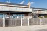 Multi unit property featuring brick siding, a balcony, a gate, and a fenced front yard