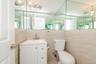 Bathroom featuring toilet, vanity, and tile walls
