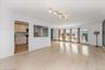 Unfurnished living room featuring light wood finished floors and baseboards