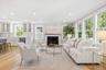 Large family room features gas fireplace, wall of large oversized windows, open to kitchen, french door leading to back deck and backyard.