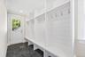 Large mudroom with custom built-ins and shiplap. Door leading to driveway and back yard. Perfect for everyday unloading of groceries, family etc... ea