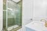 An emerald-tiled glass shower with brushed-gold fixtures. In summer, Bodhi's beach shack at Corey Beach, about 0.7 miles away, pours frozen cocktails 