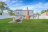 Rear exterior of yard featuring a white privacy fence enclosing a lawn and patio
