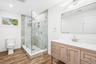 A full bath with glass shower and warm wood vanity. Tomorrow's plan: the Eggs Amsterdam at JT's Cafe on Montauk Highway, under a mile away, then a lap