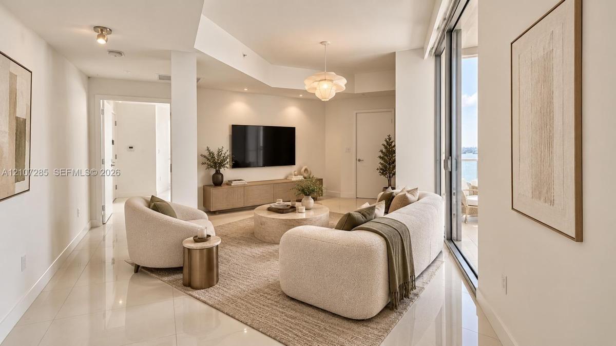 Living area featuring polished tile flooring, recessed ceiling lighting, a decorative pendant fixture, and expansive sliding glass doors ( AI used for