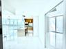 Open-concept kitchen featuring light wood-finish cabinetry, a central island with a stone countertop, built-in stainless steel appliances, white tile 