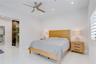 High-gloss stone-finish flooring, recessed ceiling lighting, brushed-nickel ceiling fan, and white shutter window treatments