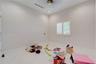 Neutral interior featuring white stone-finish flooring, high ceilings with recessed lighting, and a dual-tone circular light fixture