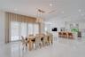 Open-concept interior featuring large-format polished stone flooring, recessed ceiling lighting, a multi-globe linear chandelier, and a kitchen island