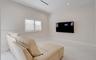 Neutral-toned interior featuring large-format tile flooring, recessed ceiling lighting, a wall-mounted linear HVAC vent, and a window fitted with whit