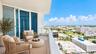 Private balcony featuring oversized tile flooring, glass panel railings, and floor-to-ceiling sliding glass doors ( AI used for interiors )