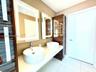 Floating double vanity featuring rectangular vessel sinks, quartz countertop, integrated wood-finish cabinetry, and back-lit mirrors with chrome fauce