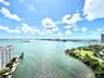 Expansive water expanse featuring a shoreline park, tropical vegetation, and bridge infrastructure