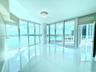 Floor-to-ceiling glass walls, polished white tile flooring, wraparound balcony, and crystal flush-mount ceiling fixture