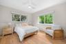 Bedroom featuring wood-finish flooring, two large sliding windows, and a ceiling-mounted light fixture