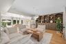 Built-in floor-to-ceiling cabinetry with arched shelving, wood-finish flooring, recessed lighting, and dual dome-style pendant fixtures
