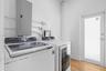 Laundry area featuring wood-finish flooring and a white exterior door with glass paneling