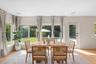Expansive picture windows, light wood-finish flooring, arched doorway, and built-in ceiling speakers