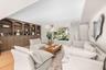 Custom floor-to-ceiling built-in cabinetry, wood-finish flooring, recessed lighting, and large picture window