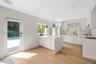 Kitchen featuring white cabinetry, quartz countertops with a waterfall edge, wood-finish flooring, recessed lighting, and arched glass-panel door