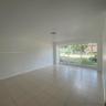 Interior space featuring neutral wall tones, large-format ceramic tile flooring, and a expansive floor-to-ceiling multi-pane window