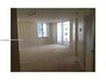 Open interior space featuring neutral wall-to-wall carpeting, floor-to-ceiling glass panel door, large multi-pane windows, and track lighting