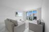 Living space featuring stone-finish flooring and floor-to-ceiling glass sliding doors providing access to a private balcony