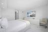 Neutral interior featuring large-format stone-patterned flooring, recessed ceiling lighting, and smooth finish walls