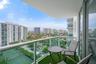 Covered balcony featuring glass pane railings and metal frame finish