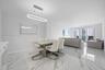 Polished stone-finish flooring, modern oval LED pendant lighting, and full-height glass balcony doors