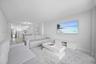Open-concept area featuring tile flooring, white cabinetry, stainless steel kitchen appliances, and recessed ceiling lighting